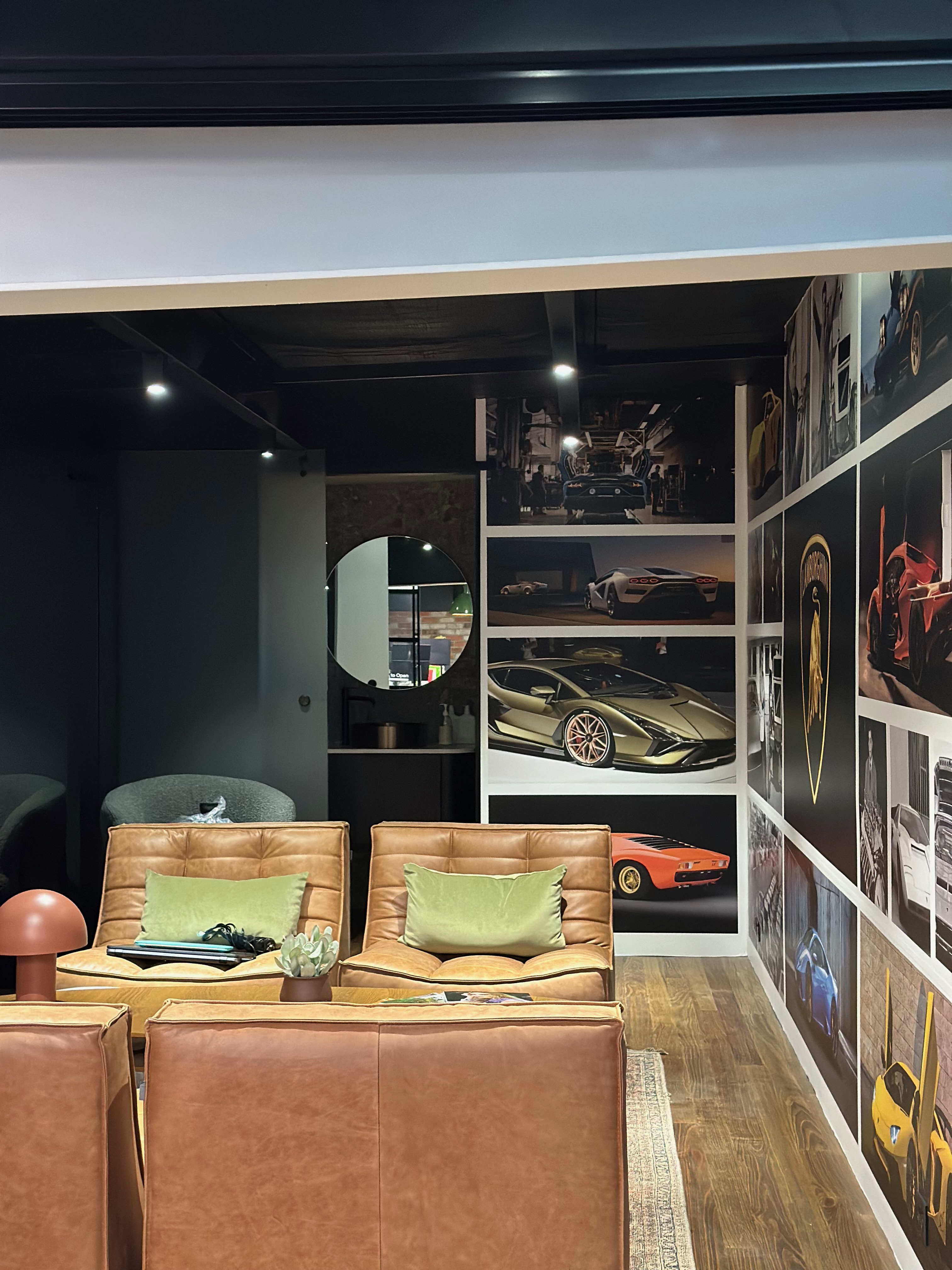 Luxury car showroom lounge area with leather furniture and car photography wall display